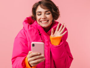 Chica con chaqueta rosa y teléfono