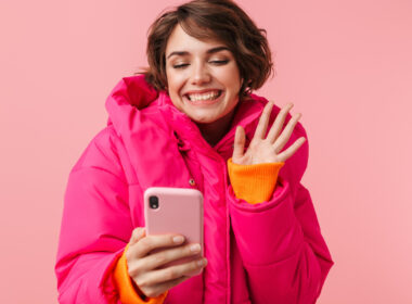 Chica con chaqueta rosa y teléfono
